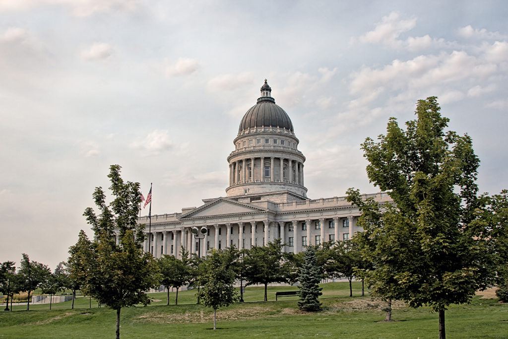 a large building with a dome and trees in the foreground