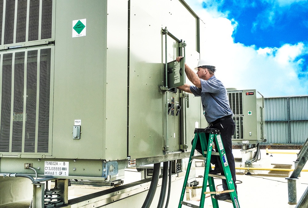 a man on a ladder working on an electrical device