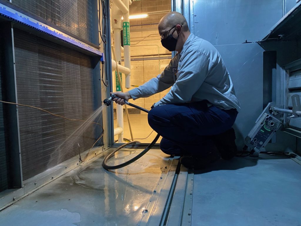 a man is using a hose to clean the floor