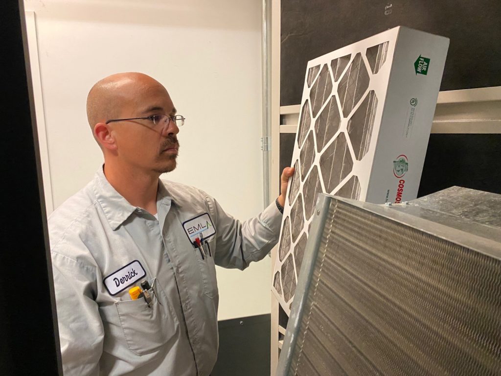 a man in a gray shirt is looking at a air filter